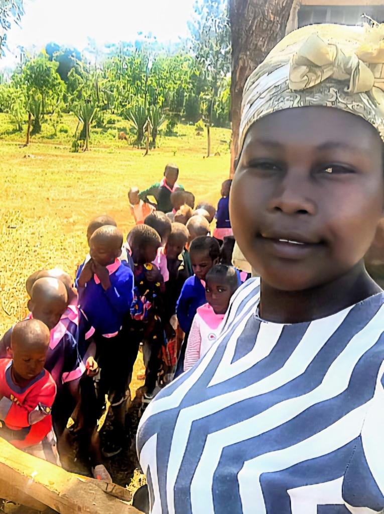 An African woman in the foreground and young African girls in the background
