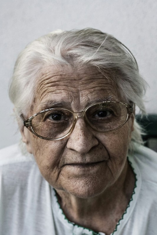 close-up photo of face of elderly woman with white hair and glasses